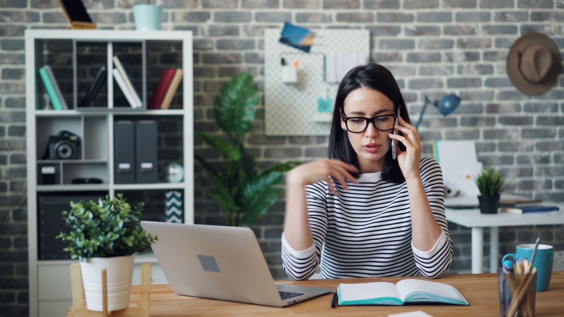 A prospective renter on the phone at a desk, taking notes